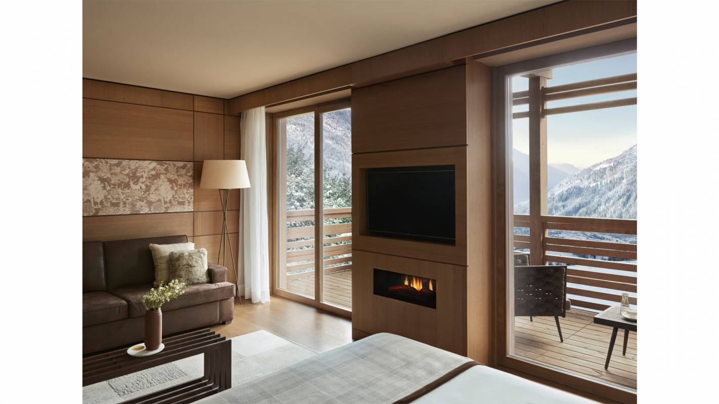 Room with fireplace and a large balcony overlooking the Dolomites