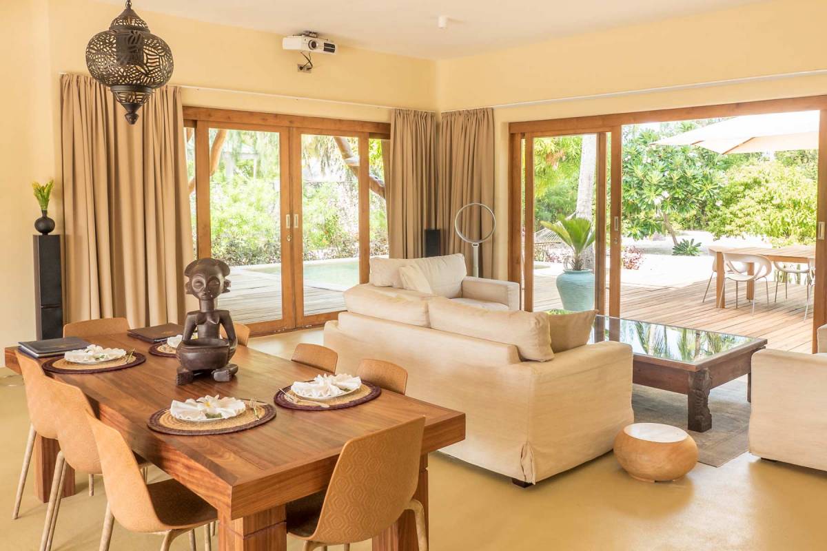 Blick auf den Esstisch und ein Sofa im Wohnbereich einer Präsidenten-Villa im Zanzibar White Sand