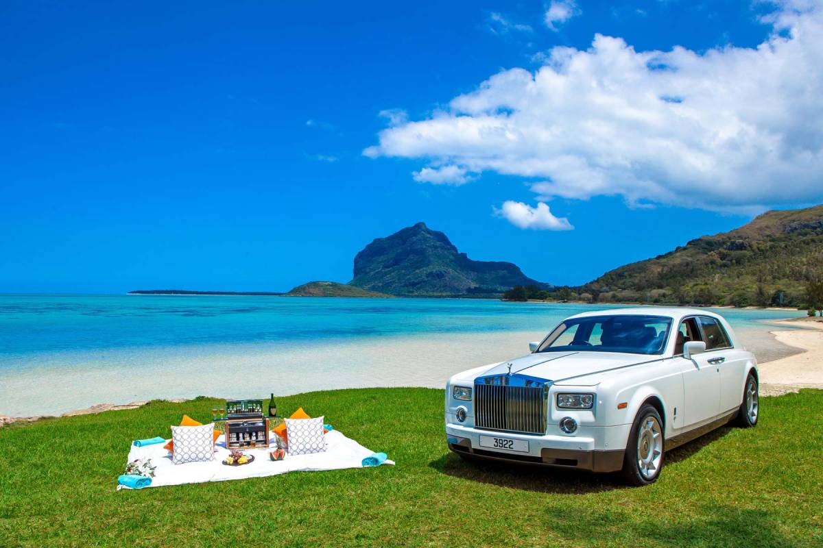 Picknickdecke am Strand neben einem Rolls Royce